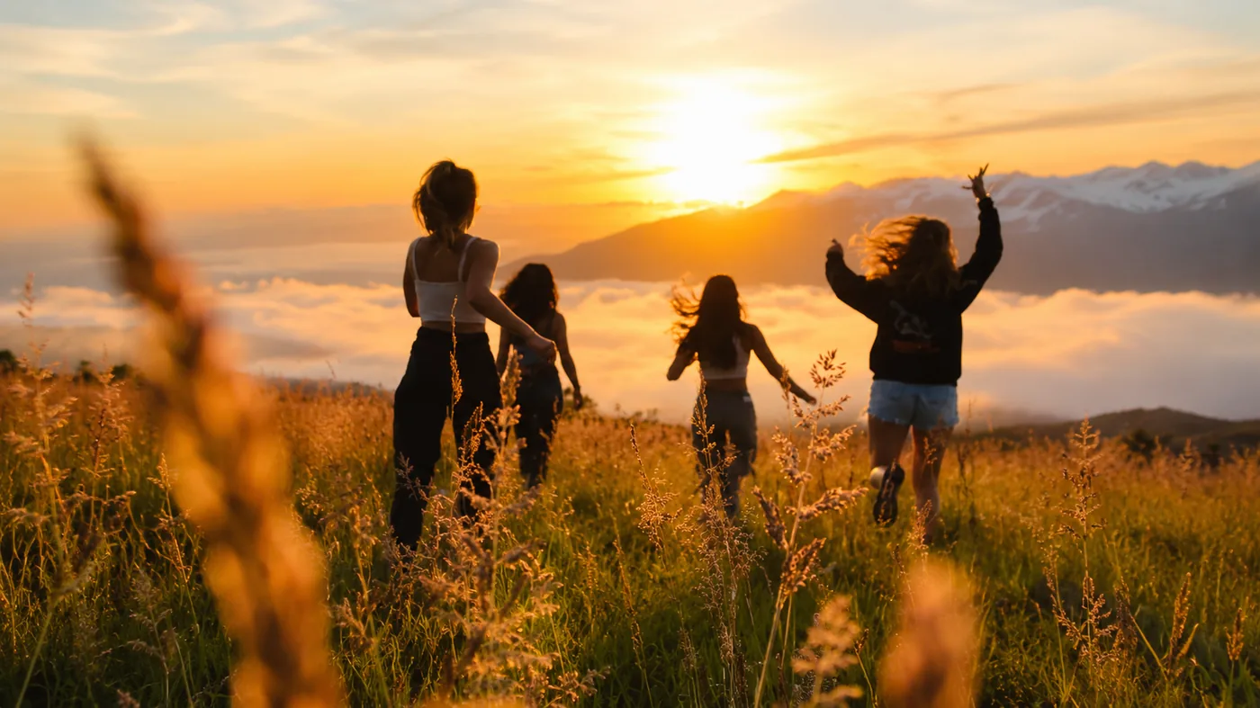 Women running through a sunset field, full of natural energy
